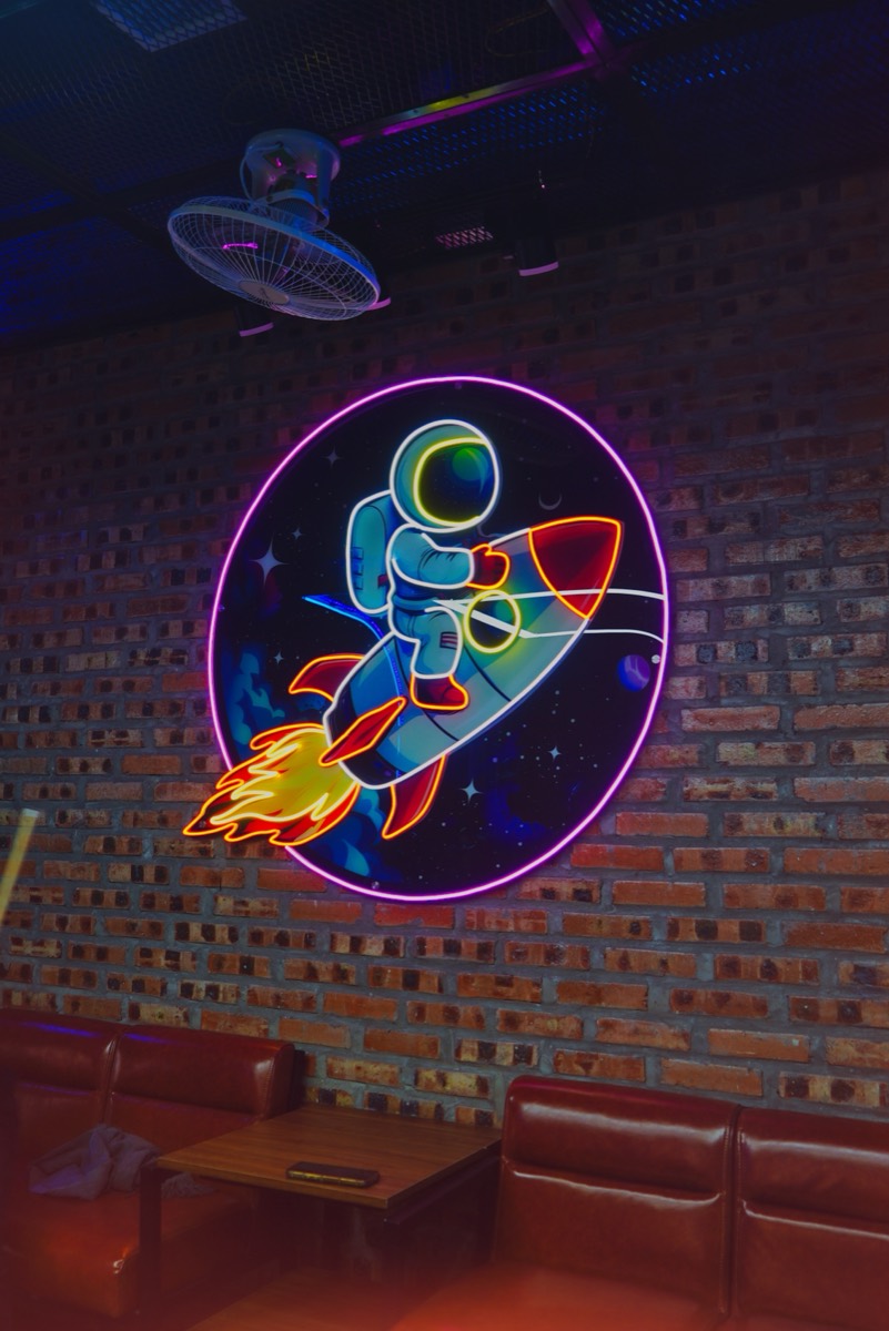 Đèn neon theo yêu cầu: neon hình phi hành gia lắp trên tường gạch quán bida