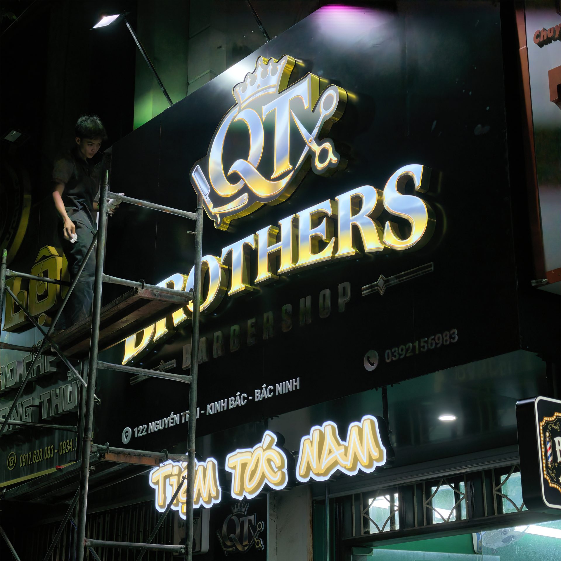 Biển hiệu barbershop tại Bắc Ninh cho QT Brothers Barbershop 6 Thợ làm việc trên giàn giáo khi hoàn thiện biển QT Brothers Barbershop