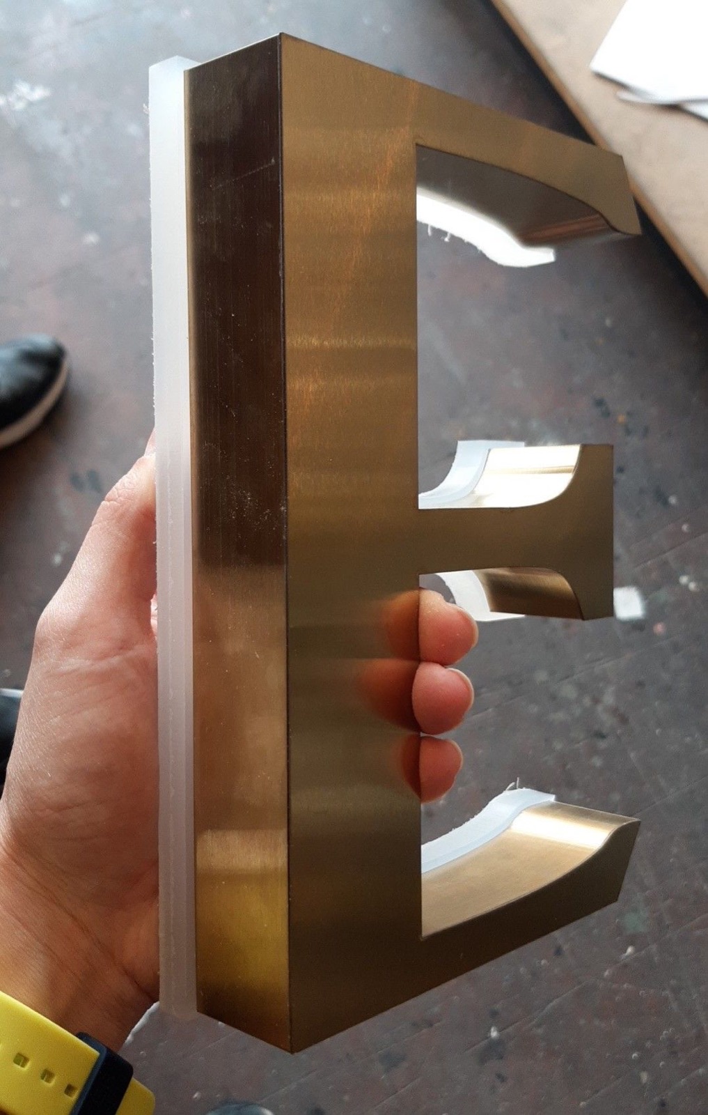 Chữ inox vàng gương, xước hay sơn màu: loại nào hợp với cửa hàng của bạn 3 Mẫu chữ kim loại màu vàng với phần đế sáng, minh họa trong bài chữ nổi inox