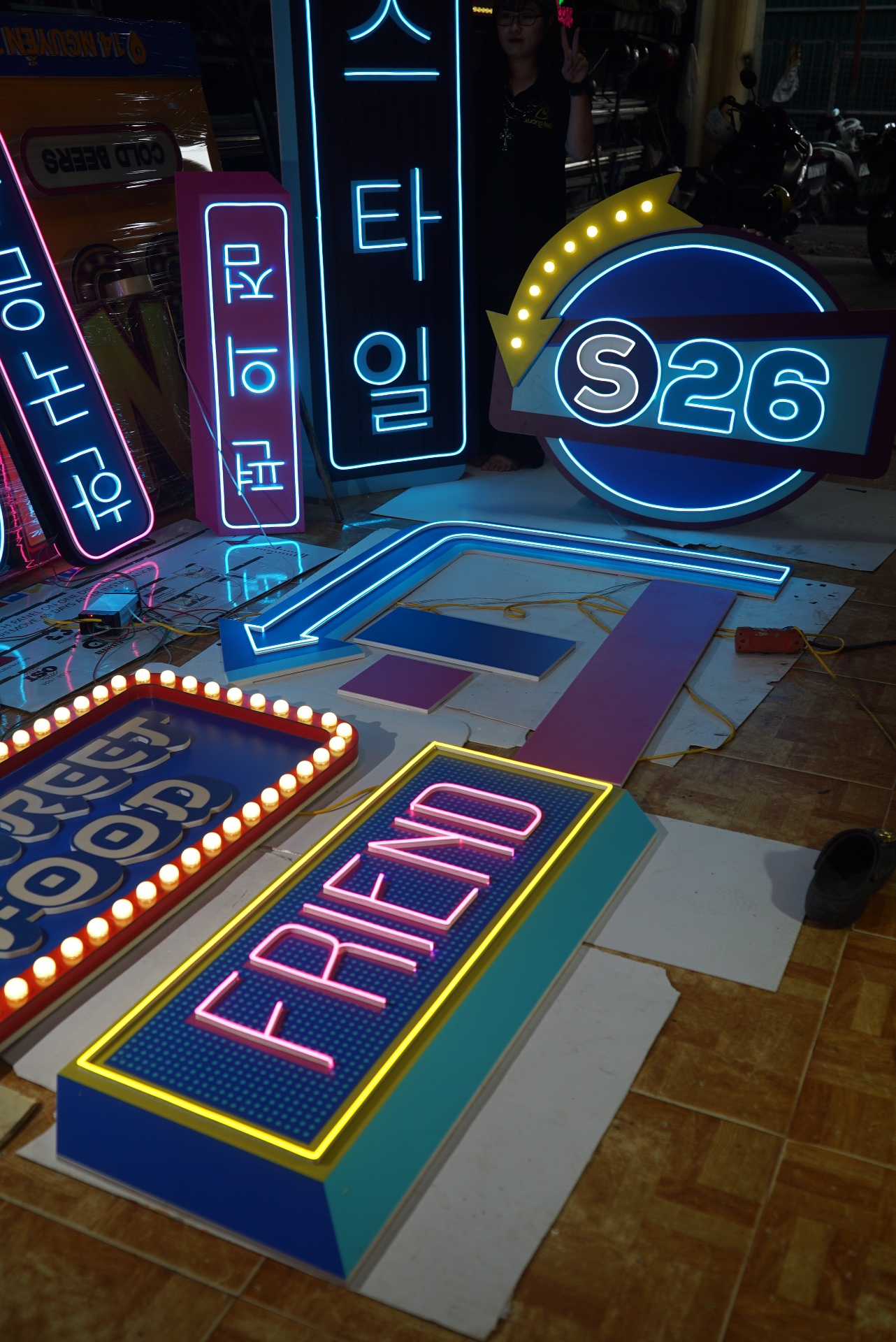 Đèn neon trang trí cửa hàng tiện lợi S26 tại Thanh Hoá 9 Logo S26 và bảng chữ FRIEND phát sáng cạnh các biển chỉ dẫn nền xanh