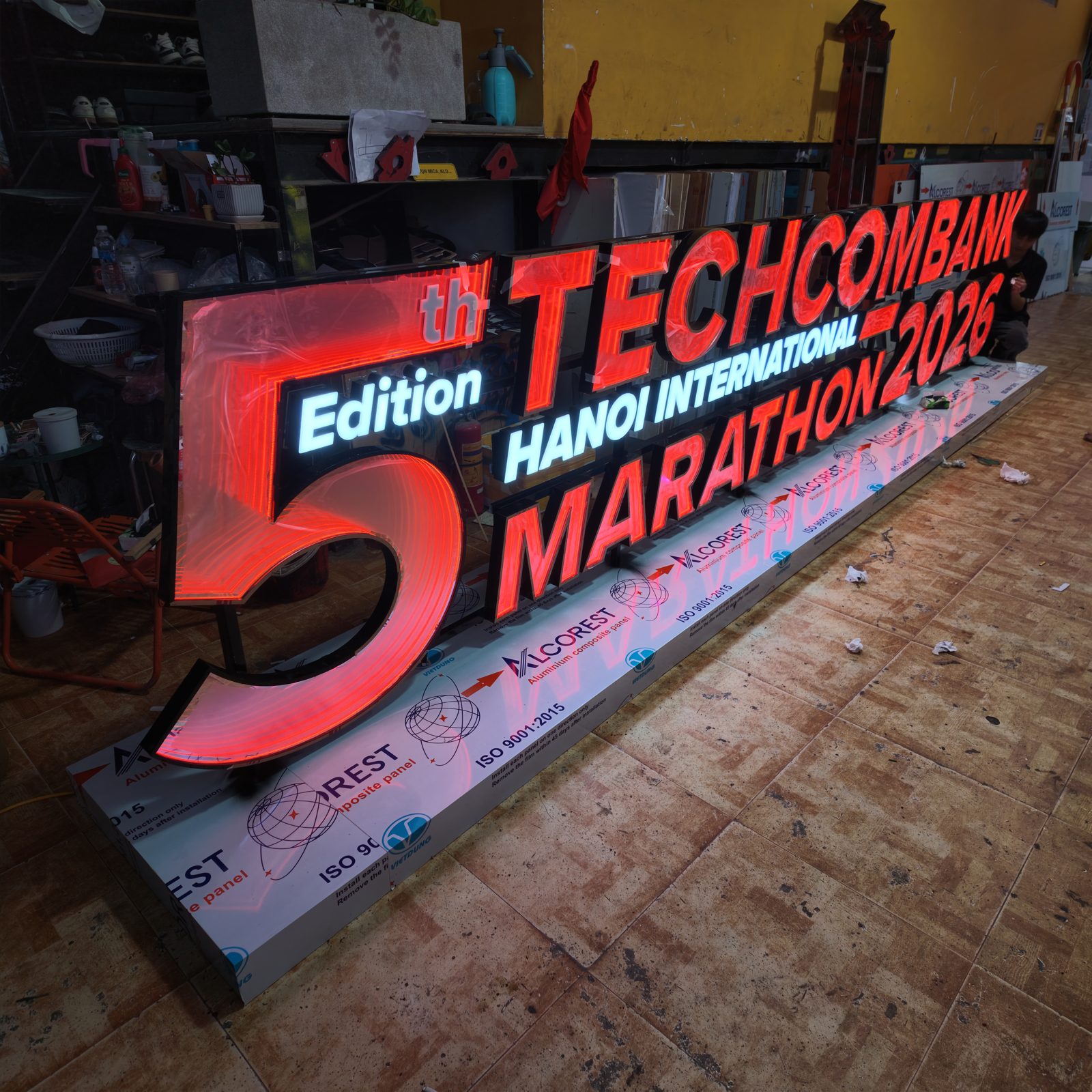 Thi công biển neon vô cực nổi khối cho khu check in Techcombank Hanoi International Marathon 2026 11 Cụm biển chữ cho khu check in đang được hoàn thiện